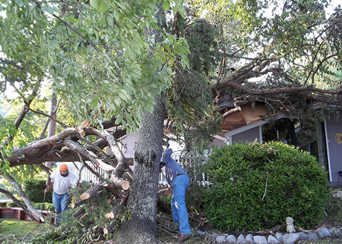Storm Damage cleanup in front of blue home
